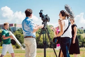 model in the make-up during video shoot on production set with camera and sound engineer on stand-by