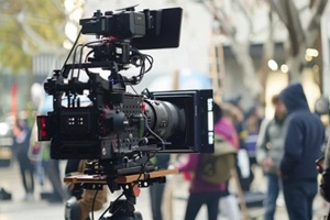 professional video camera is set up on a bustling city street, capturing scenes for a film production