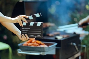 worker holds a film clapper shooting a summer barbecue commercial
