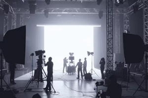 commercial video film movie making lighting set professional studio production big working people silhouette scenes behind television camera motion picture equipment crew photo light