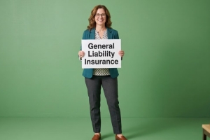 Businesswoman Holding a Board with General Liability Insurance Text