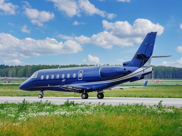 Blue private jet on the runway.