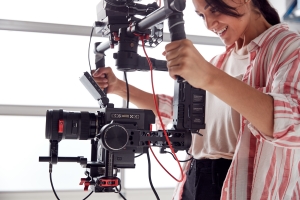 Female Videographer with Video Camera on Steady Cam Rig Filming Movie